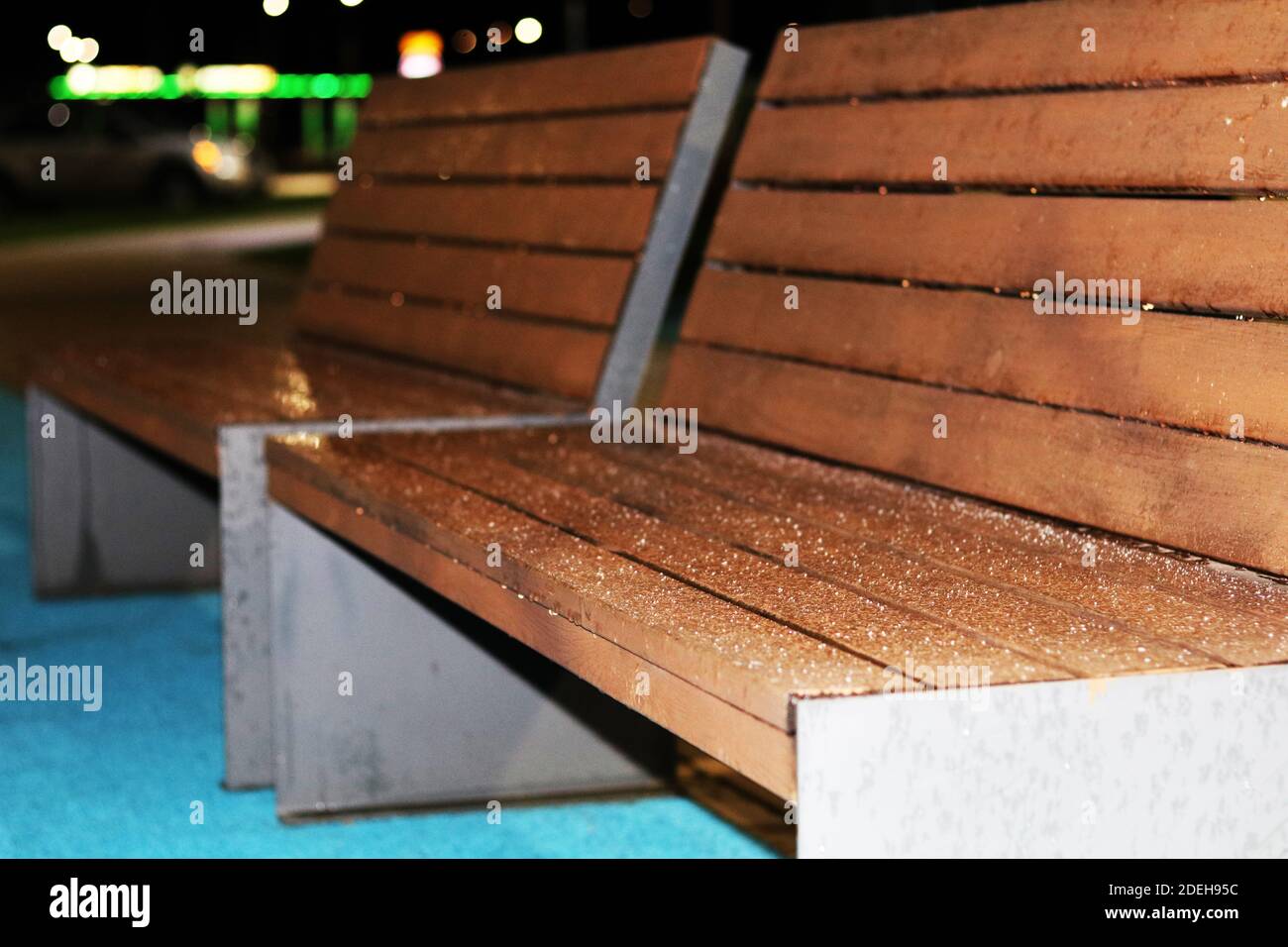 Holzbank draußen im Dunkeln mit Frost bedeckt Stockfoto