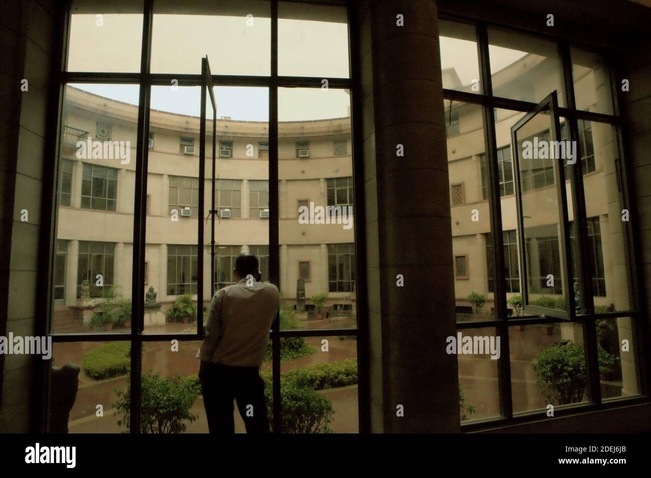 Ein Mann, der auf dem Gehweg steht, mit Blick auf den zentralen Gartenhof des indischen Nationalmuseums in Neu-Delhi, Indien. Stockfoto Ein Mann, der auf dem Gehweg steht, mit Blick auf den zentralen Gartenhof des indischen Nationalmuseums in Neu-Delhi, Indien. Stockfoto