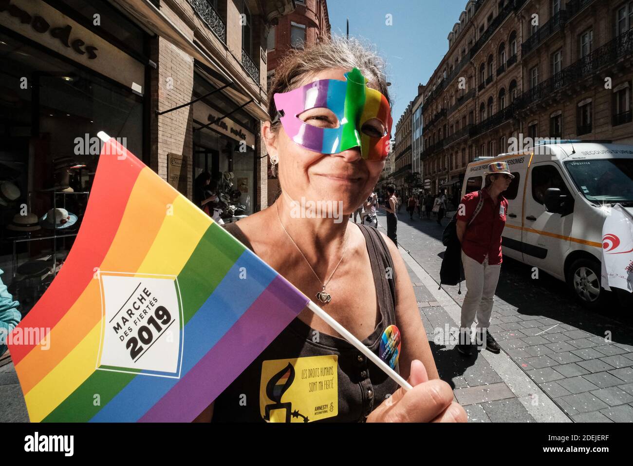 Regenbogen Maske und Gay Pride Flagge. 25 Jahre nach der ersten "Marche des  Fiertés" (Gay Pride), sammelte Toulouse (Frankreich) am 8. Juni 2019 etwa  30,000 Menschen. Porträts von festlichen Wanderern, Verteidiger von