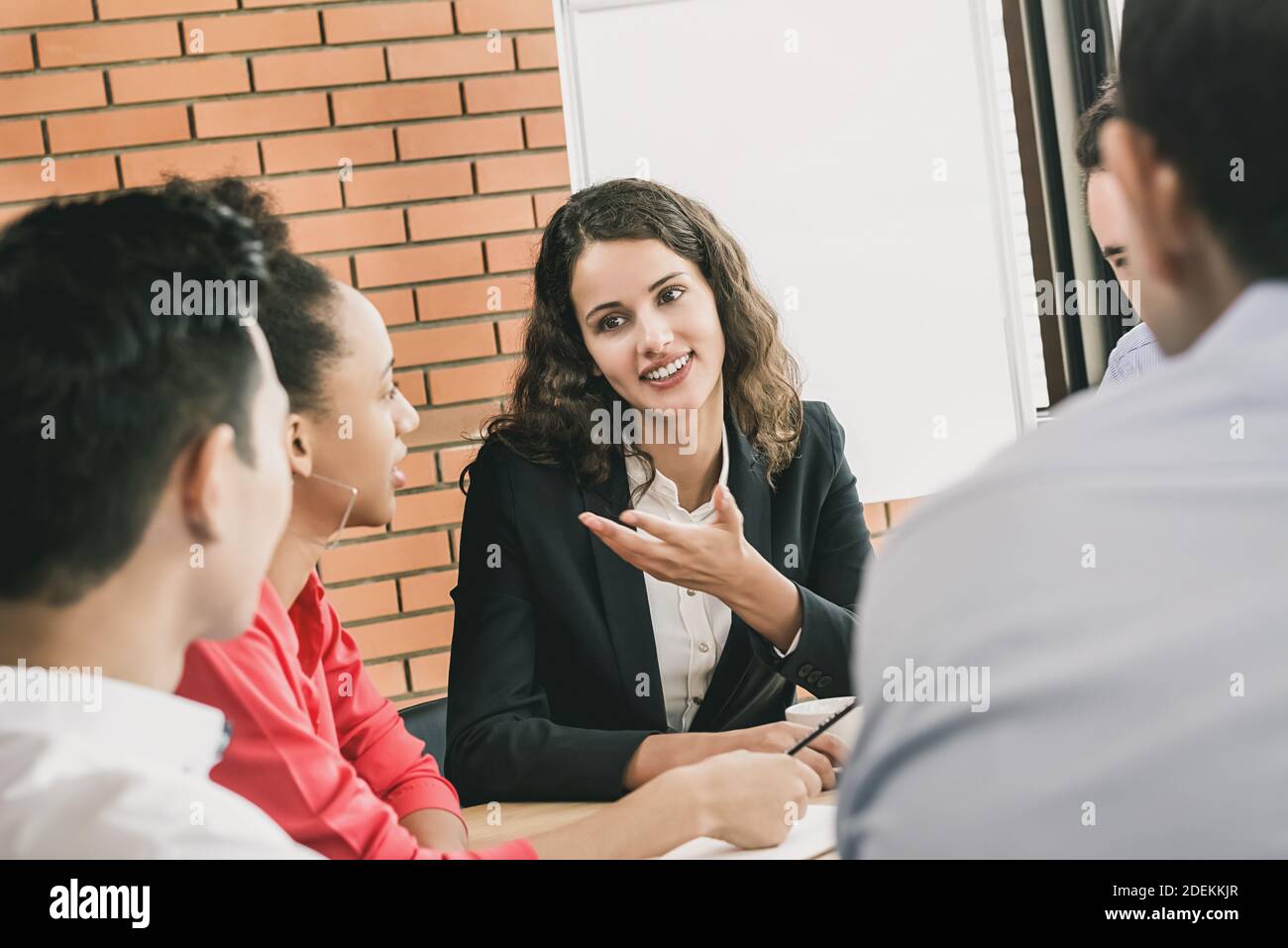 Geschäftsführerin im Gespräch mit ihren Kollegen bei der Besprechung Im Büro Stockfoto