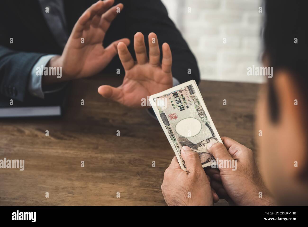 Rich Geschäftsmann bietet japanische Yen Geldscheine an die andere Person, aber er weigert sich - Anti-Birbery und Korruption Konzept Stockfoto