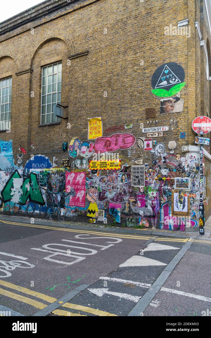 Graffiti-Poster an einer Wand in der Buxton Street, Spitalfields, London E1 England, Großbritannien Stockfoto