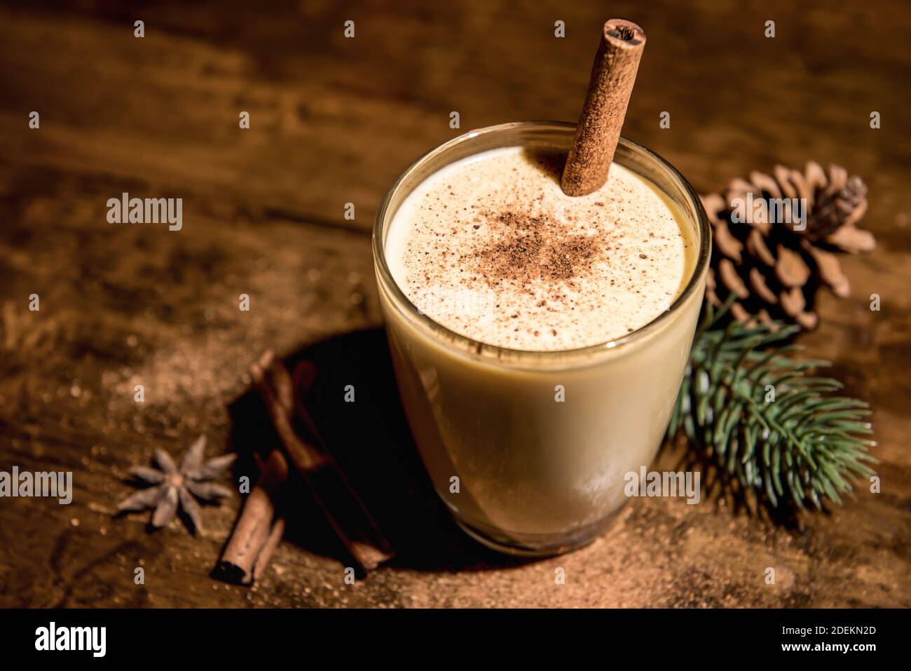 Hausgemachtes traditionelles Weihnachten Eierteller trinken in einem Glas mit gemahlener Muskatnuss, Zimt und Dekoration Artikel auf Holztisch, Vorbereitung für die Feier fest Stockfoto