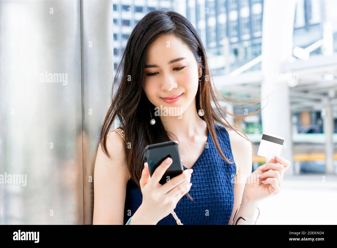 Schöne junge asiatische Frau, die Zahlung digital mit Kreditkarte Nach dem Online-Shopping mit Handy-Anwendung Stockfoto