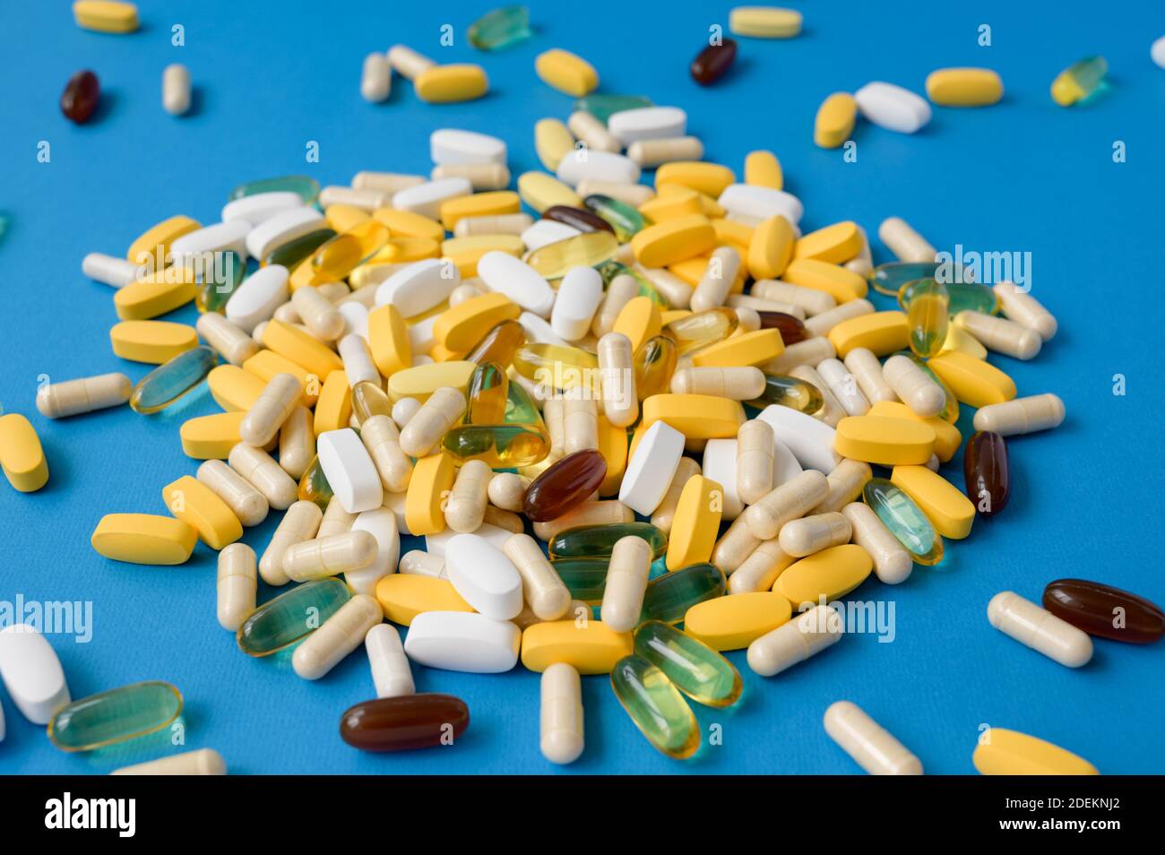 Viele Pillen Tabletten Softgels und Kapseln auf blauer Oberfläche Stockfoto