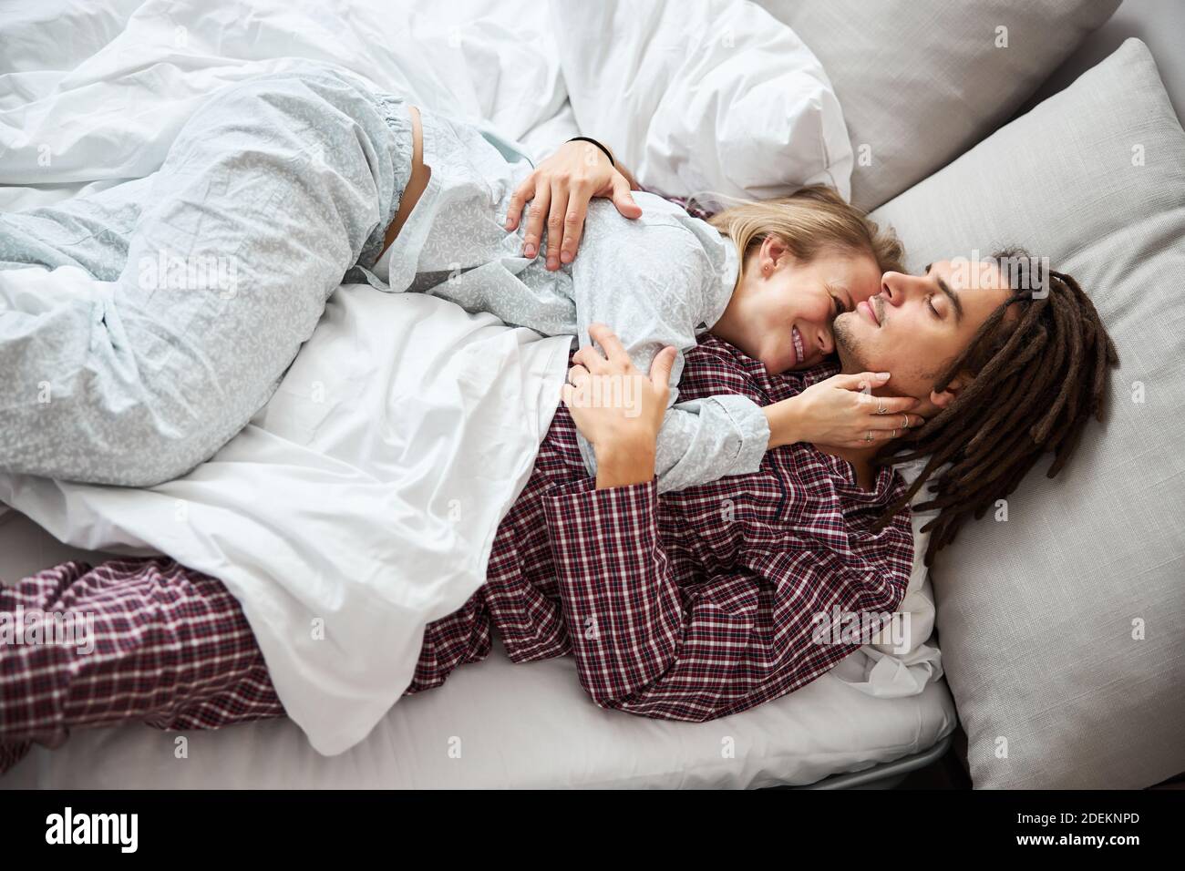 Glücklich junges Paar in der Liebe Kuscheln im Bett Stockfotografie - Alamy