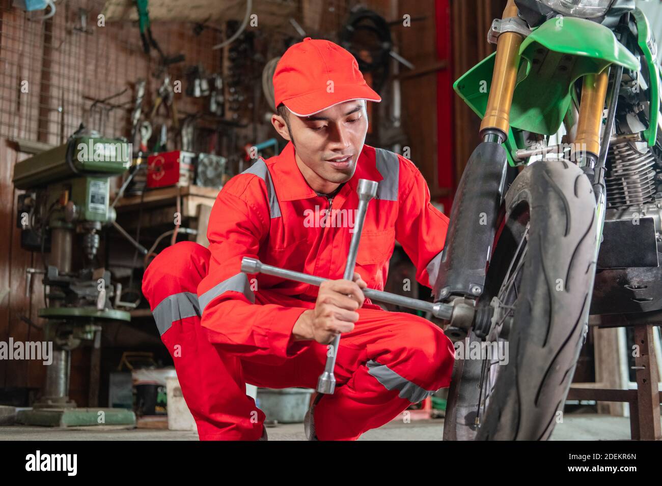 Die Mechaniker verwenden Radmuttern, um die Motorräder in der Reparatur zu entfernen Geschäfte Stockfoto
