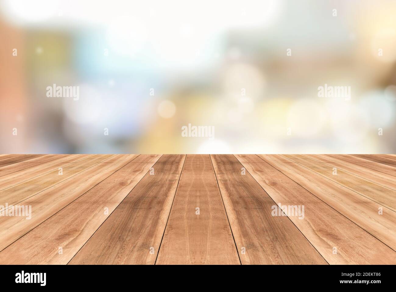 Schräge Ansicht der natürlichen Holzmuster Tischplatte gegen verschwommen Bokeh Cafe Hintergrund geeignet für Montage oder Anzeige Ihrer Produkte Stockfoto