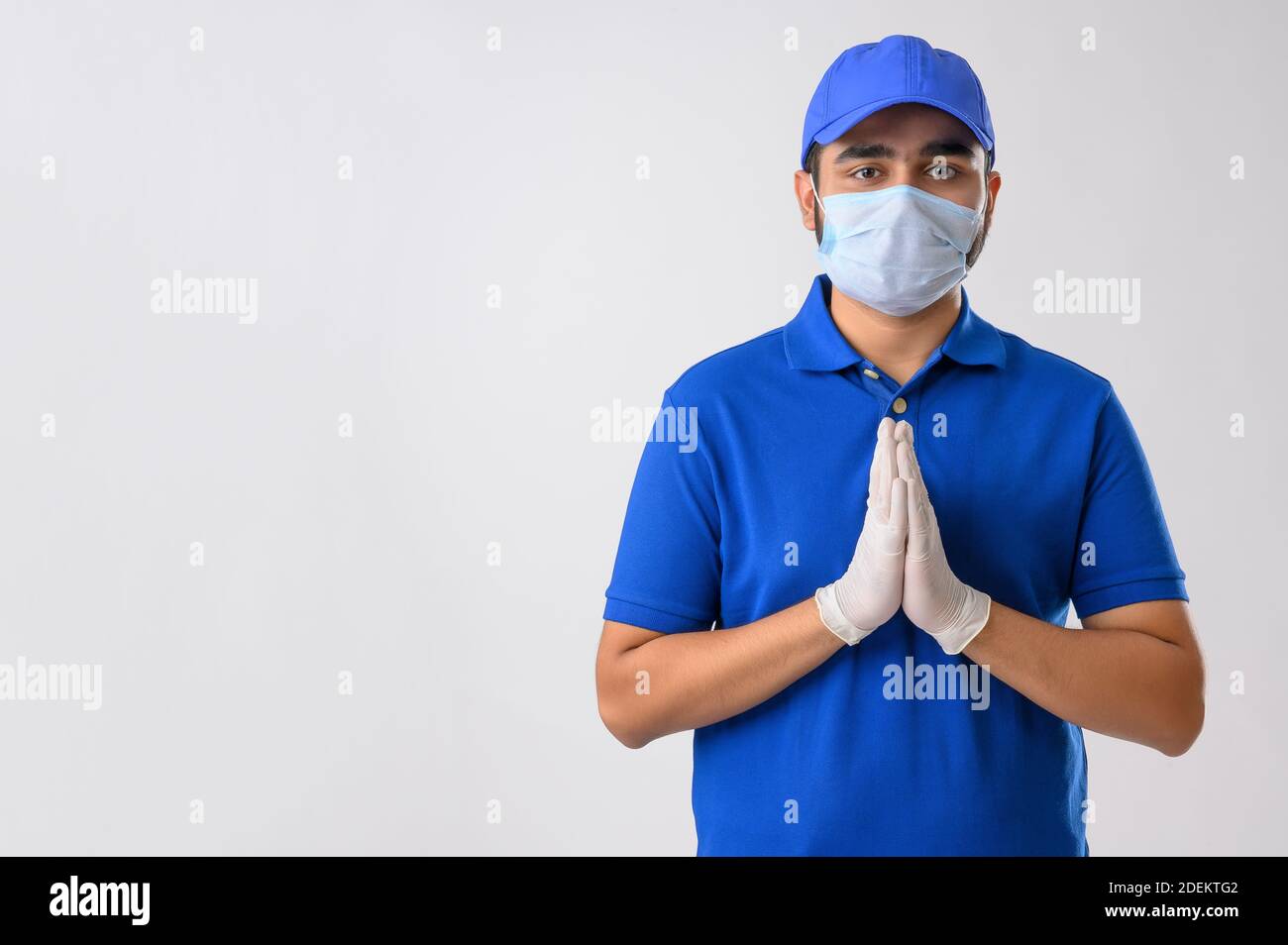 Junger Mann in Dienstuniform stehend und Begrüßung mit seinem Hände verbunden Stockfoto