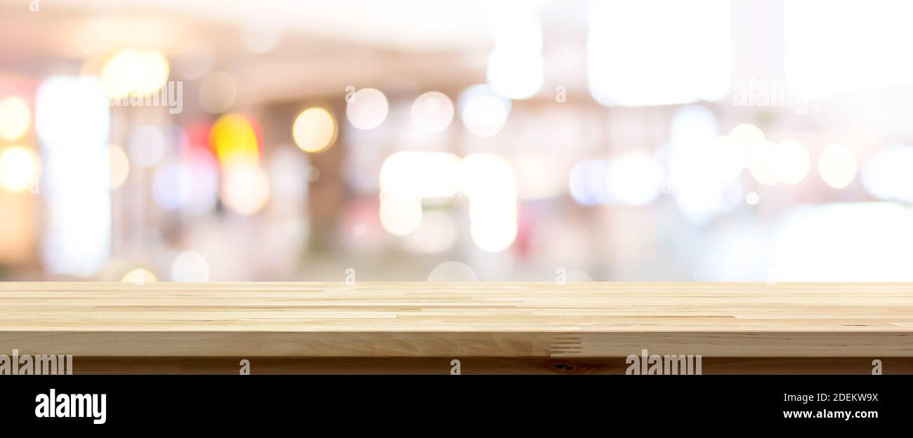 Seitenansicht der natürlichen Holzmuster Tischplatte gegen verschwommen Heller Bokeh Hintergrund in Café geeignet für Montage oder Anzeige Ihre Produkte (Lebensmittel) Stockfoto