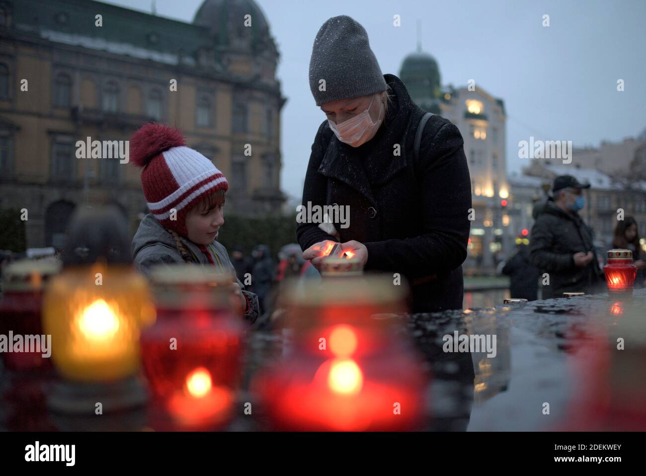 Non Exclusive: LVIV, UKRAINE - 28. NOVEMBER 2020 - EINE Frau und ein Kind zünden eine Mahnlaterne in Erinnerung an die Opfer der Hungersnot von 1932-1933, bekannt ein Stockfoto
