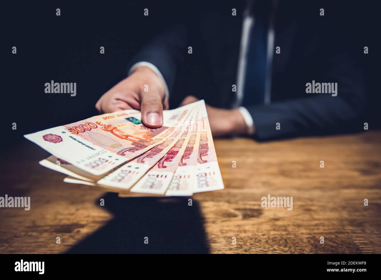 Geschäftsmann, Geld, russische Rubel Banknoten, über seinen Schreibtisch in einem dunklen Büro - Bestechung und Korruption Konzept Stockfoto