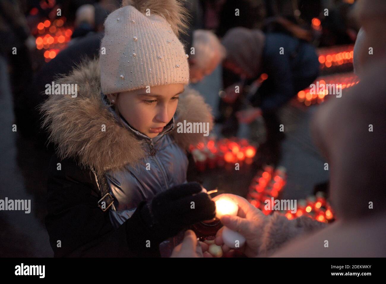 Non Exclusive: LVIV, UKRAINE - 28. NOVEMBER 2020 - EIN Mädchen leuchtet eine Mahnlaterne während einer Gedenkveranstaltung für die Opfer der Hungersnot 1932-1933, Stockfoto