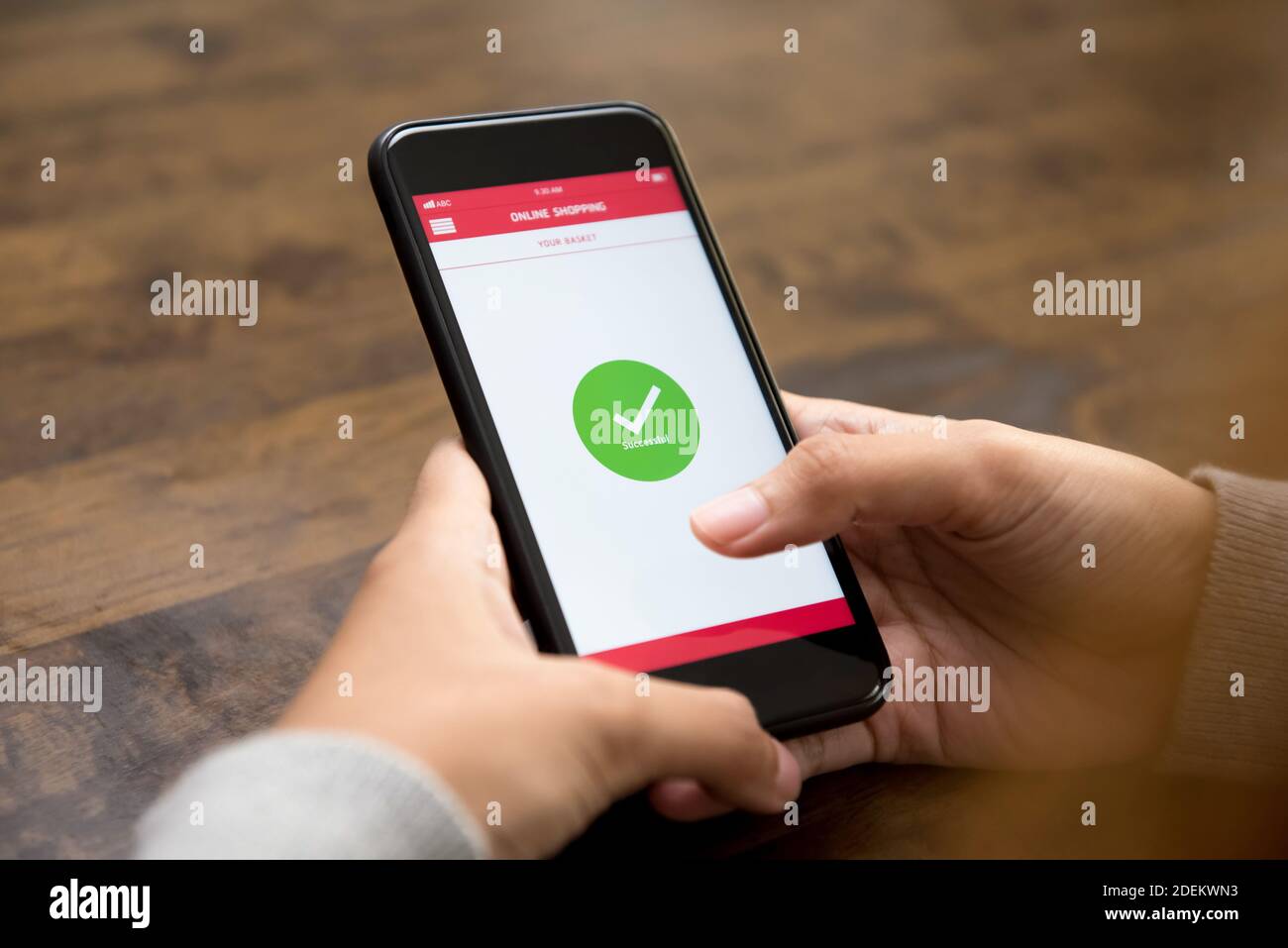 Das Bestätigungszeichen für den erfolgreichen Online-Einkauf erscheint danach auf dem Smartphone-Bildschirm Digitale Bezahlung durch eine Kundin Stockfoto