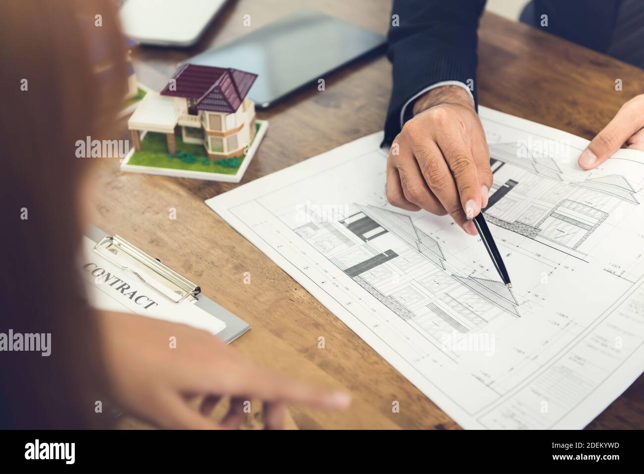 Entwickler hält und erklärt einem Unternehmen ein Wohnkonzept Frau Klientin für Immobilienentwicklung Zwecke mit einem Vertrag Vertragsvorschlag Stockfoto