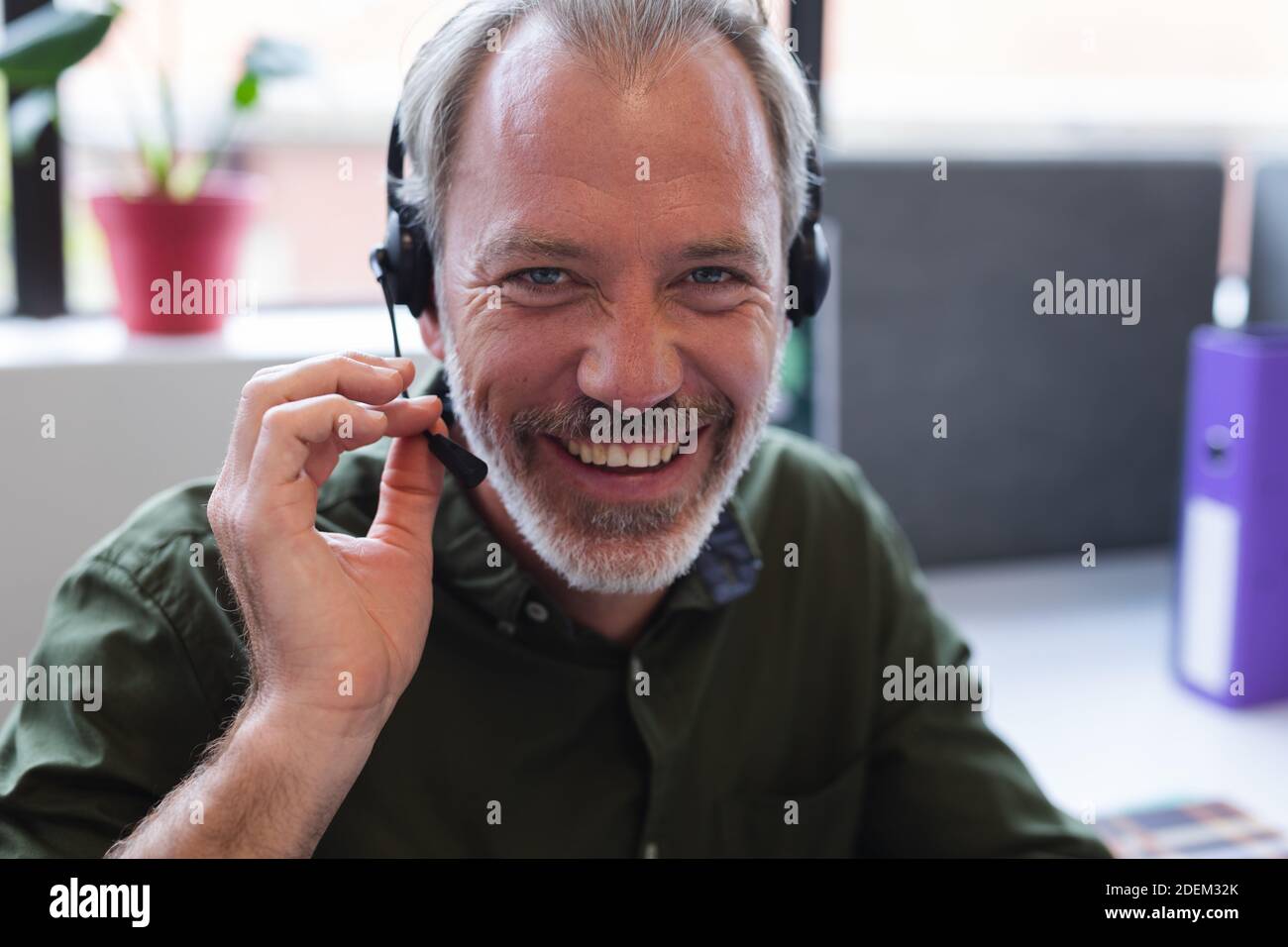 Porträt eines kaukasischen Mannes mit Kopfhörern im Büro Stockfoto