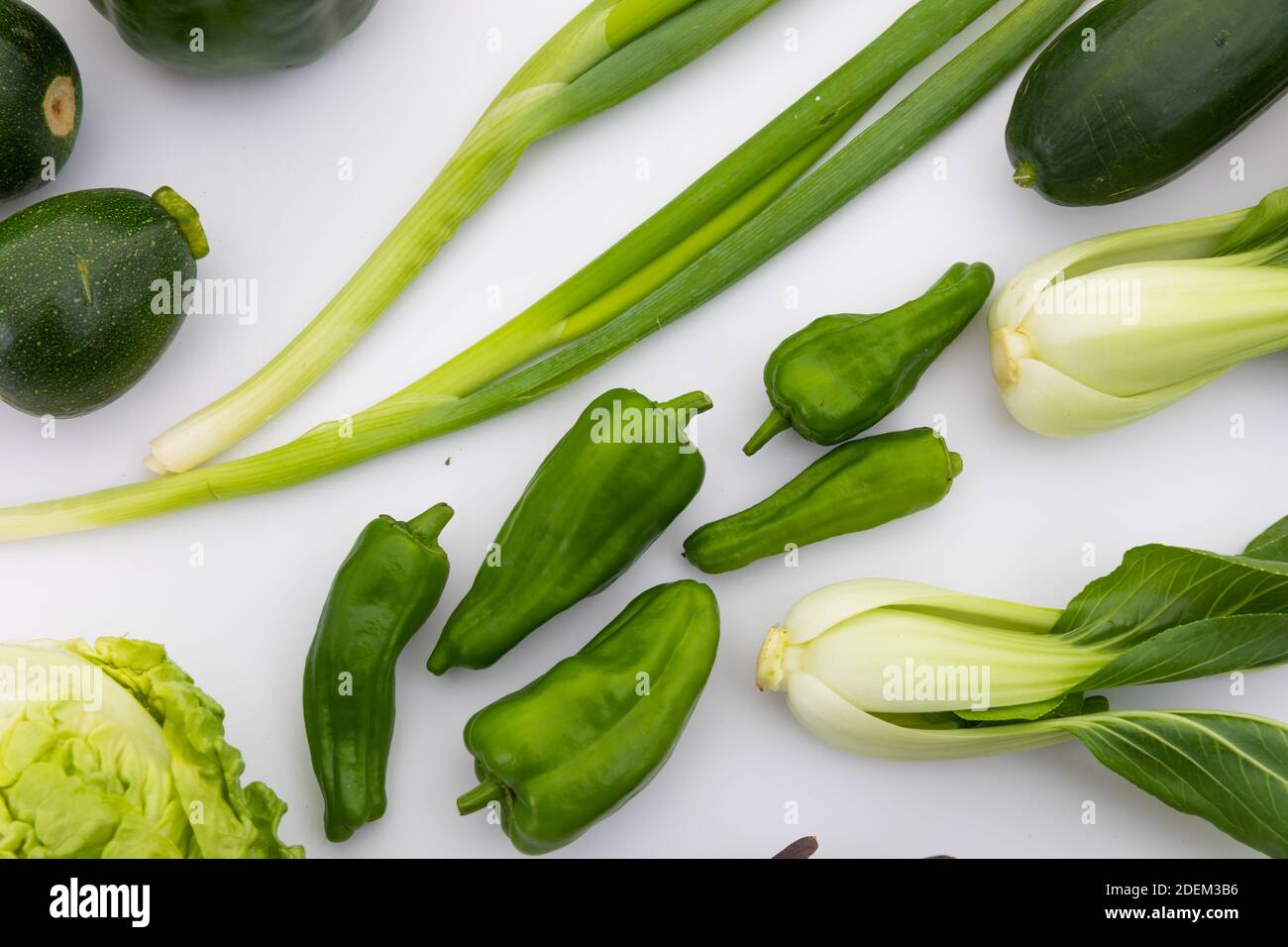 Salat, Paprika und Frühlingszwiebeln auf weißem Hintergrund Stockfoto