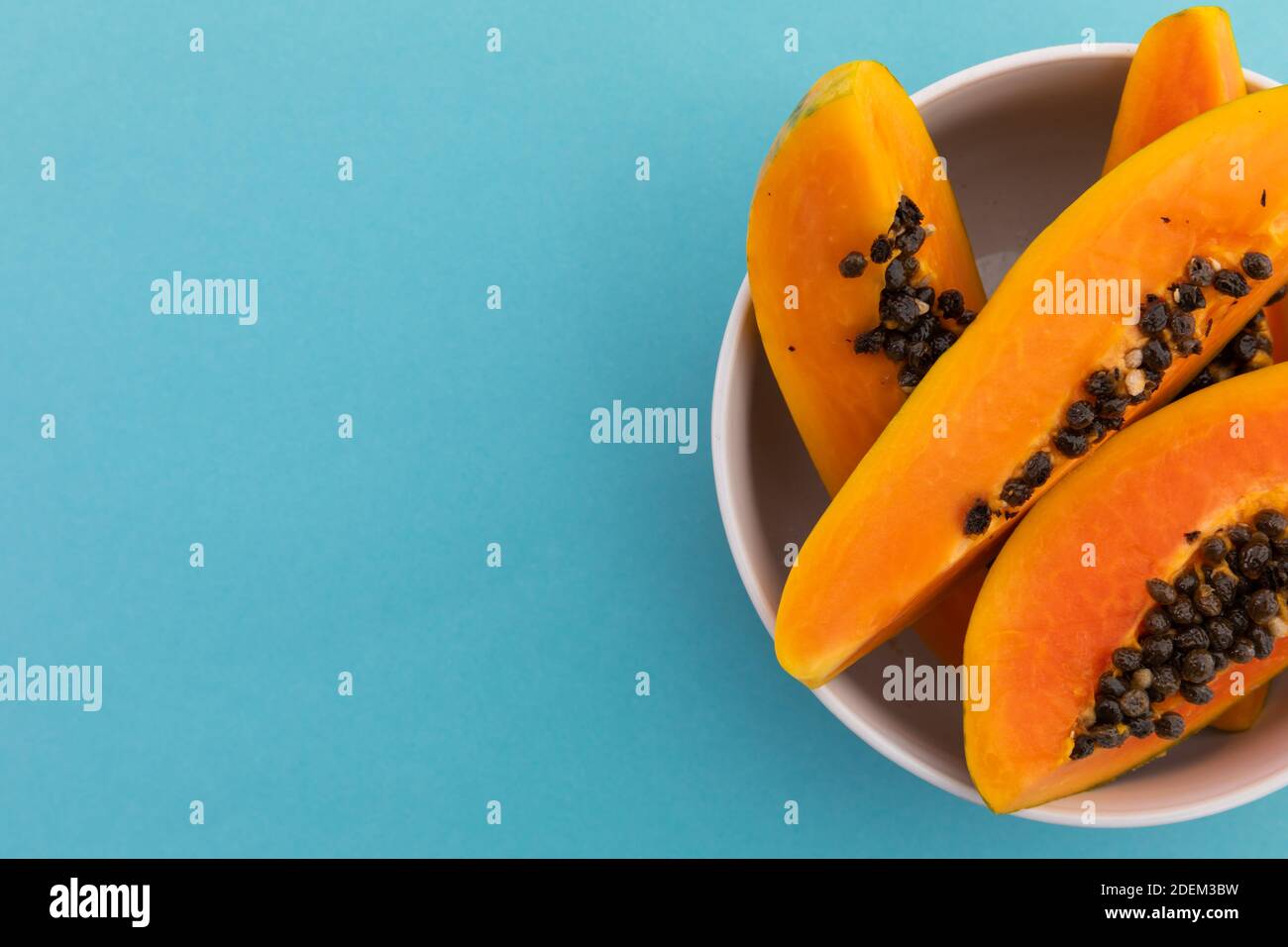 High-Angle-Ansicht der Schüssel frisch geschnittenen Papaya auf Blauer Hintergrund Stockfoto
