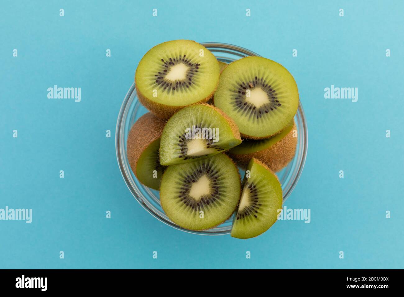 Blick auf die Schüssel mit frisch geschnittener Kiwi Blauer Hintergrund Stockfoto