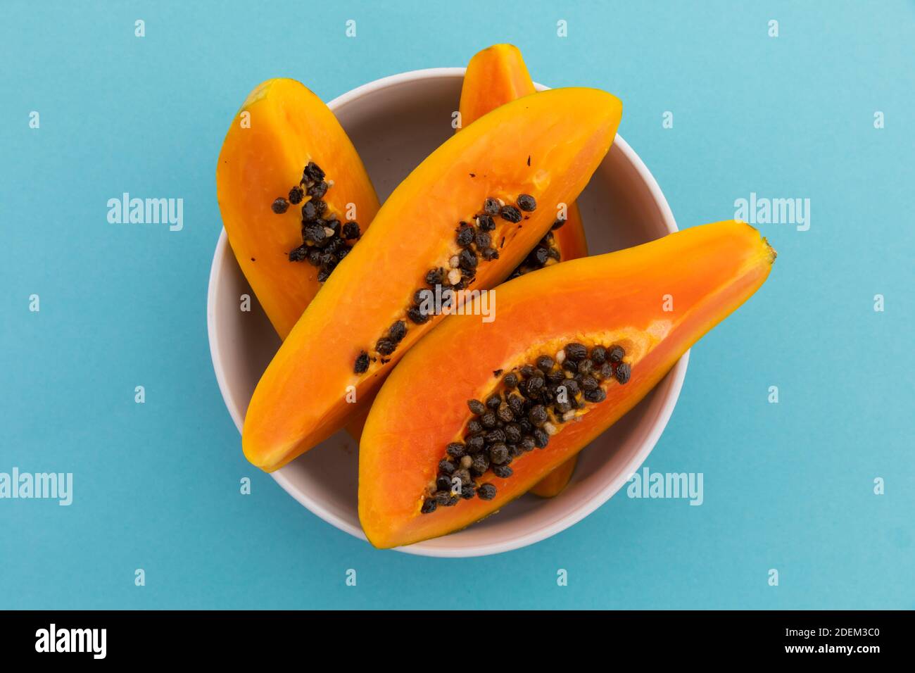 High-Angle-Ansicht der Schüssel frisch geschnittenen Papaya auf Blauer Hintergrund Stockfoto