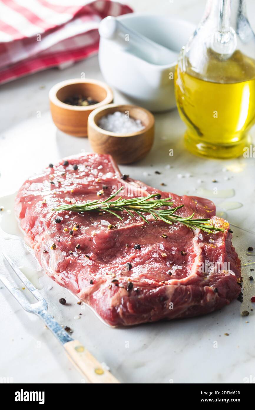 Geschnittenes rohes Ribeye Steak auf einem weißen Küchentisch. Stockfoto