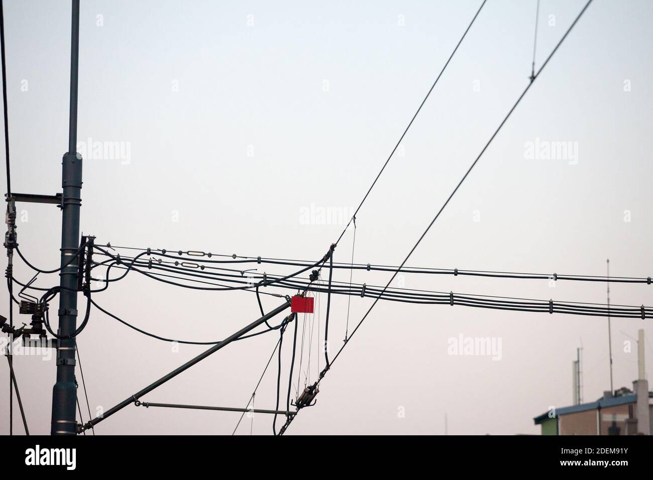 Oberleitung Oberleitung einer Eisenbahnstrecke, die Strom für Züge liefert, mit einer Mast-Säule im Hintergrund. Bild einer Oberleitung über Stockfoto