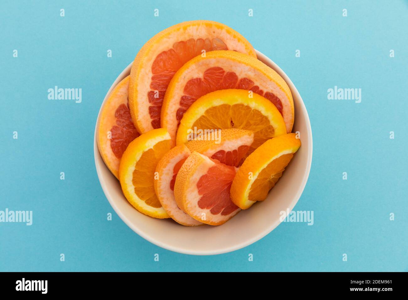 Blick in die Schüssel mit frisch geschnittenen Orangenscheiben Auf blauem Hintergrund Stockfoto