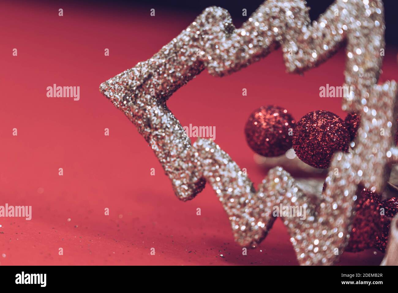 Goldene weihnachtsbaumschmuck isoliert auf einem schwarzen und roten Hintergrund. Weihnachten und Neujahr Hintergrund. Hintergrund der Feiertage. Stockfoto