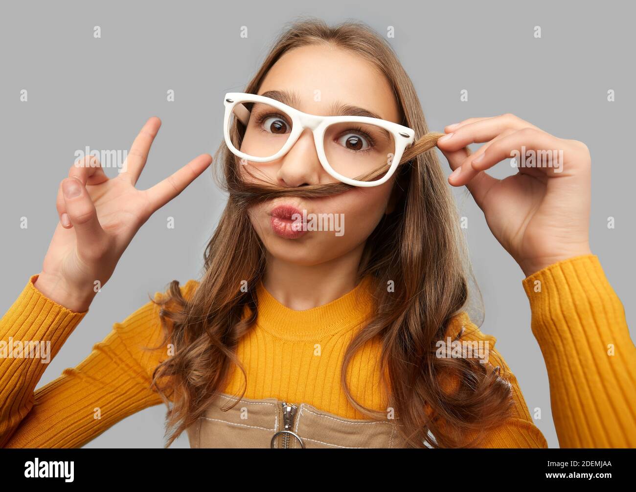 Teen Mädchen in Brille macht Gesichter und zeigt Frieden Stockfoto