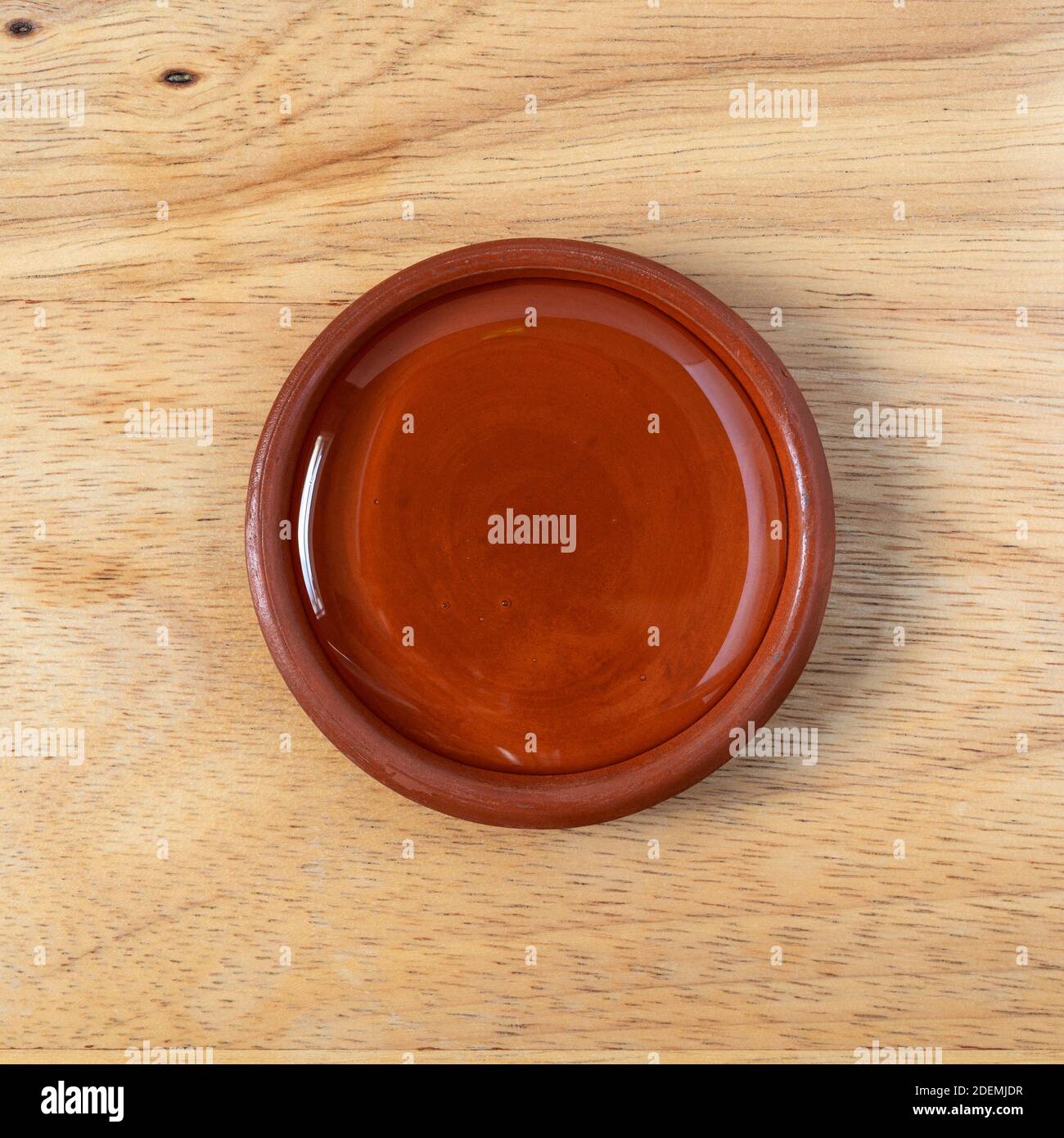 Schale aus hellem Maissirup versetzt auf einer Holz-Tischplatte beleuchtet mit natürlicher Beleuchtung. Stockfoto