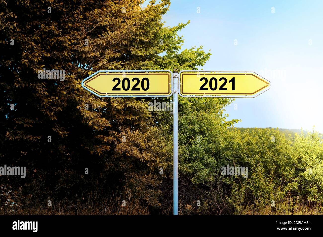 Gelbe Straßenschilder in entgegengesetzte Richtungen mit Text 2020 und 2021, die auf eine hellere Zukunft zeigen, Neujahrskonzept, Kopierraum Stockfoto