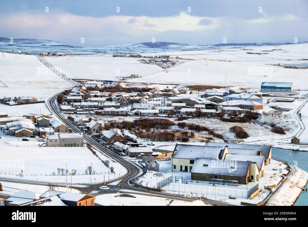 Winterszene mit Luftaufnahme der schottischen Stadt auf Orkney Insel mit Häusern und Straße von Schnee bedeckt Stockfoto