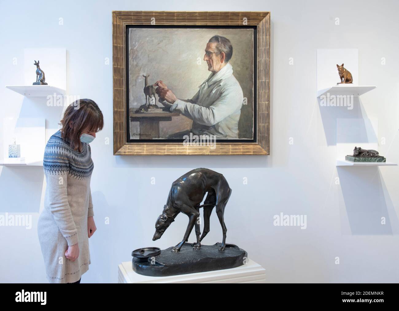 Sladmore Gallery, Mayfair, London, Großbritannien. Dezember 2020. Mit dem Einzug in die Kategorie 2 eröffnet die London Art Week Winter am 2. Dezember in Mayfair und St James’s mit der Chance, 5,000 Jahre Kunst in Covid Secure Galleries zu sehen. Sladmore Gallery Features: Hunde, Katzen und andere Best Friends - eine Auswahl von Tierskulpturen. Bild: Galerie Mitarbeiter mit: Italienischer Greyhound trinken aus einer Schüssel, lebensgroß, c.. 1880, Henri-Alfred-Marie Jacquemart, (Französisch, 1824-1896), Bronze. Quelle: Malcolm Park/Alamy Live News. Stockfoto