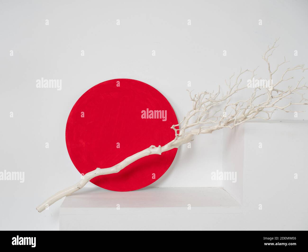 Stilvolles und minimalistisches Stillleben, orientalische Motive. Der rote Kreis und der weiße Faden, Symbol der Kirschblüte und der japanischen Flagge. Stockfoto