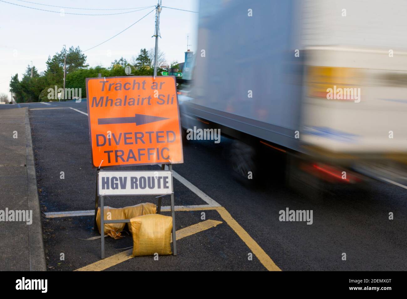 Umgelenderte Verkehrszeichen, Beschilderung, in irischer und englischer Sprache auf der N56 Hauptstraße in Ardara, County Donegal, Irland Stockfoto