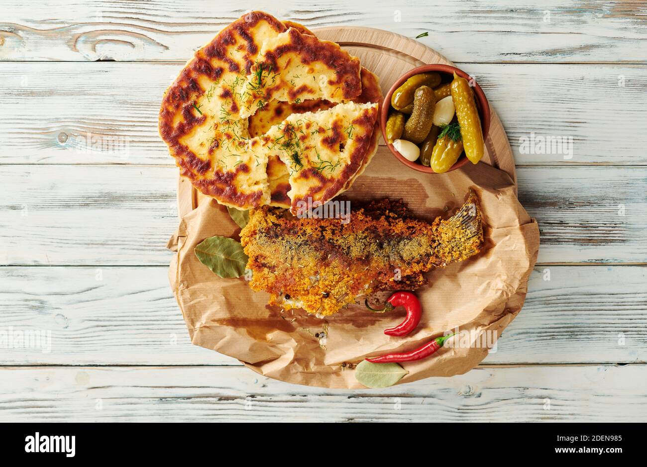 Gebratener Fisch in Papier eingewickelt mit leckeren Pfannkuchen Stockfoto