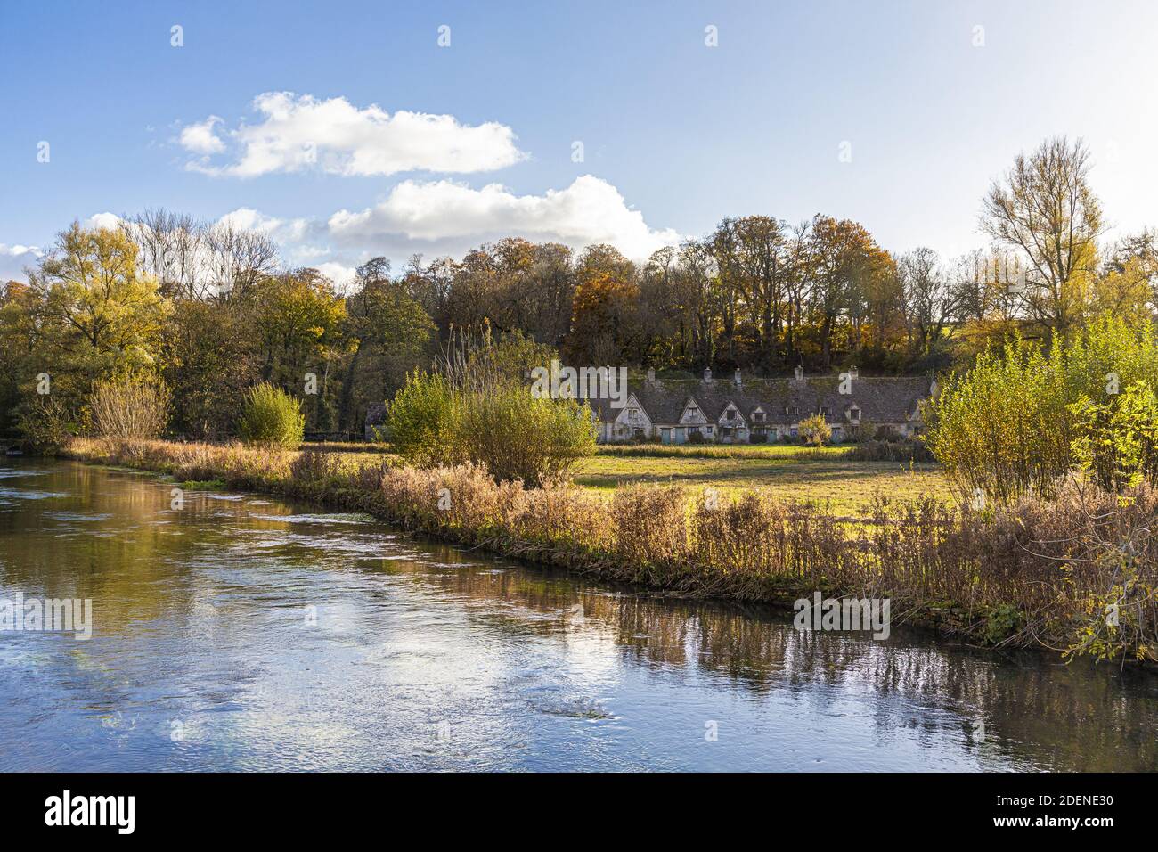 Herbst in den Cotswolds - The River Coln, Rack Isle und Arlington Row im Dorf Bibury, Gloucestershire UK Stockfoto