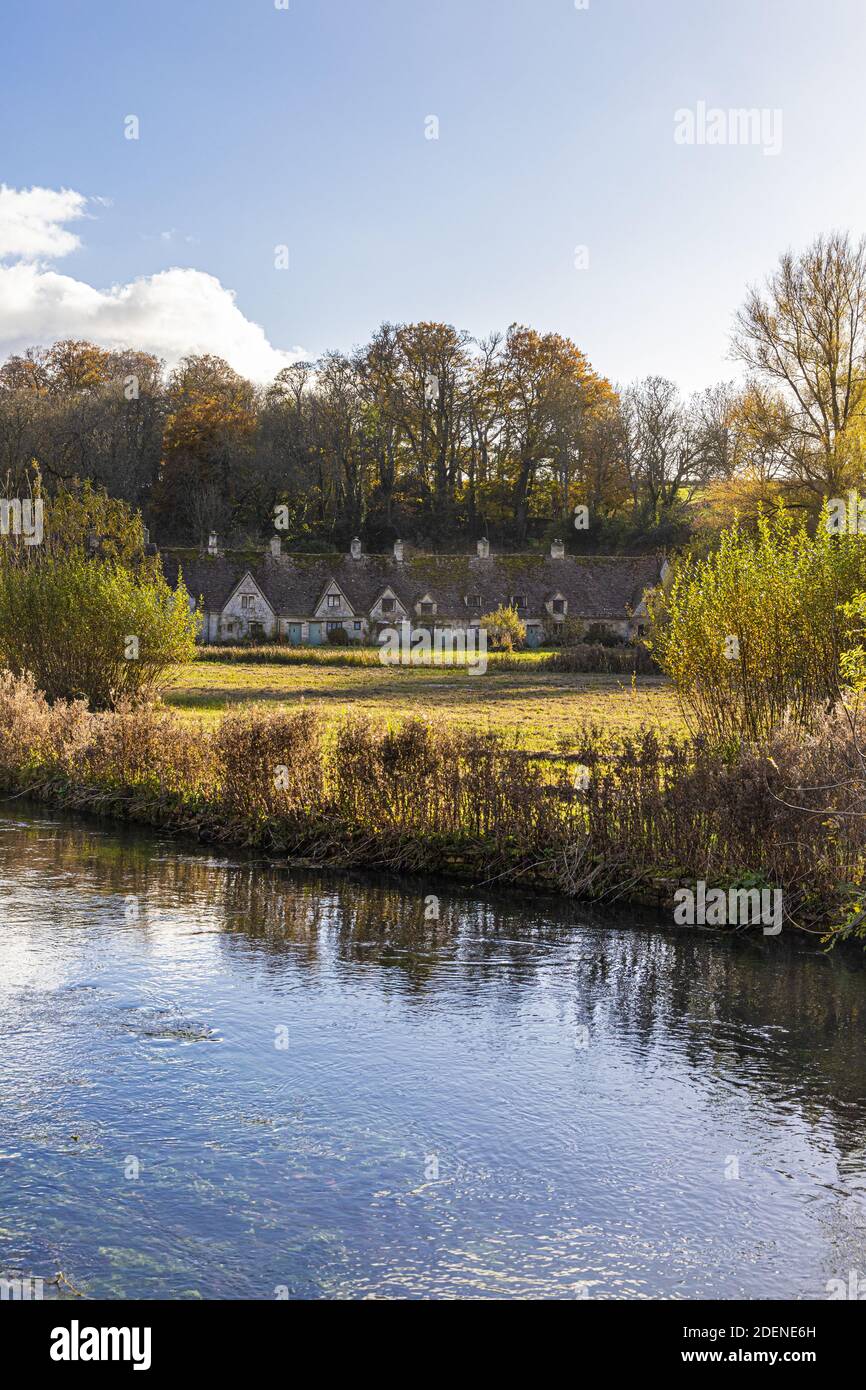 Herbst in den Cotswolds - The River Coln, Rack Isle und Arlington Row im Dorf Bibury, Gloucestershire UK Stockfoto