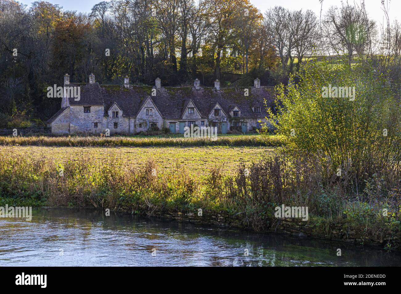 Herbst in den Cotswolds - The River Coln, Rack Isle und Arlington Row im Dorf Bibury, Gloucestershire UK Stockfoto