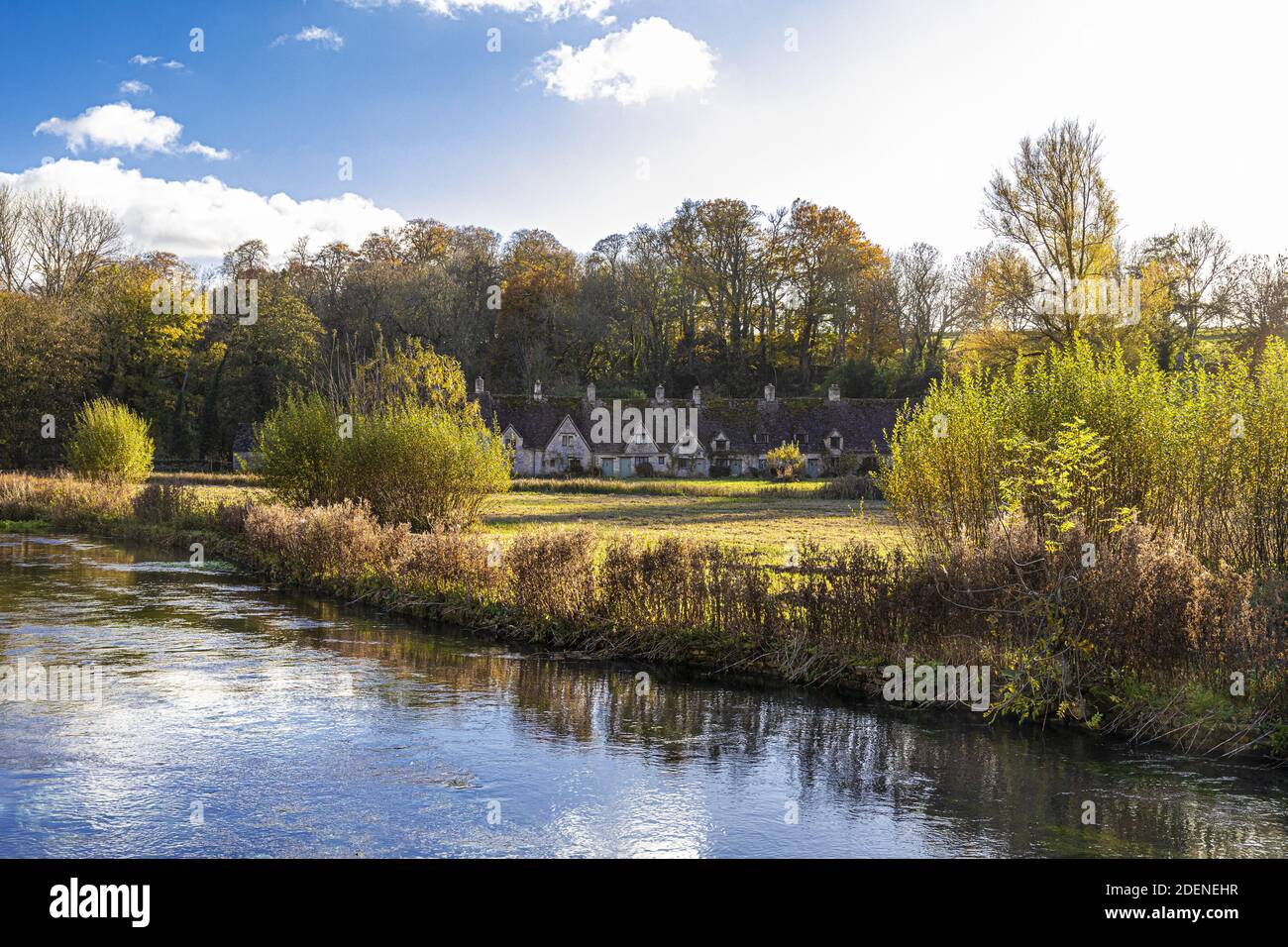 Herbst in den Cotswolds - The River Coln, Rack Isle und Arlington Row im Dorf Bibury, Gloucestershire UK Stockfoto