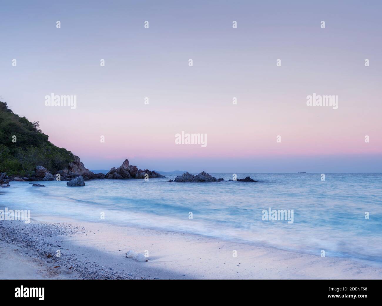 sonnenaufgang mit Muschel am Strand eine symbolische Naturkunst Design und natürliche Dekoration mit langer Belichtung Stockfoto