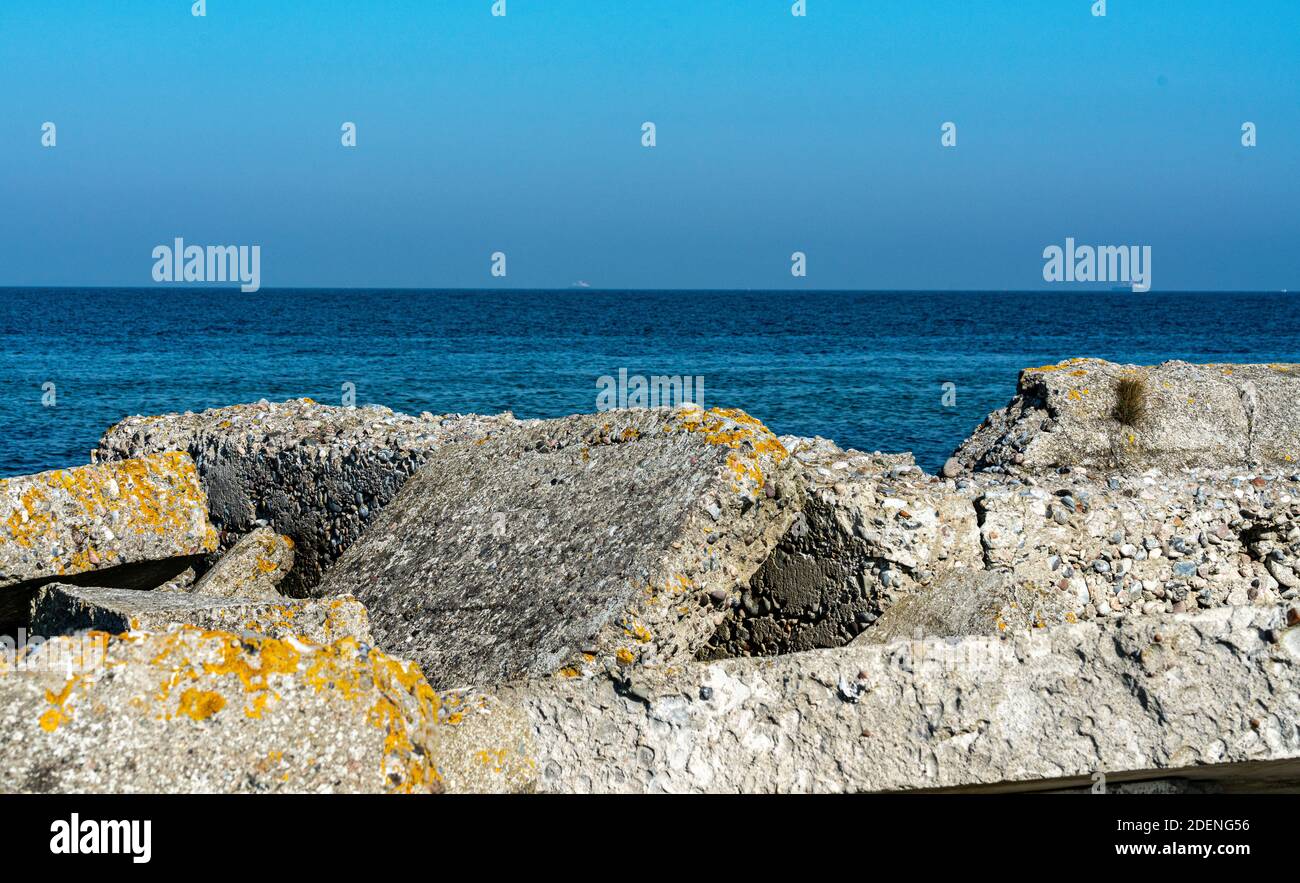 Haufen von alten zerbrochenen Betonschutt an einem Strand mit dem Meer im Hintergrund. Reste eines deutschen Bunkers aus dem 2. Weltkrieg. Stockfoto