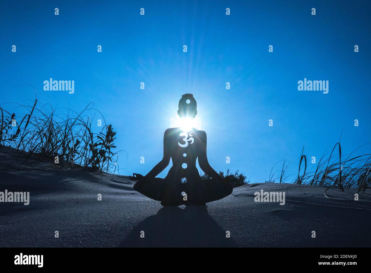 Eine Silhouette einer Person, die mit einem offenen Hals meditiert Chakra unter dem Sonnenlicht Stockfoto
