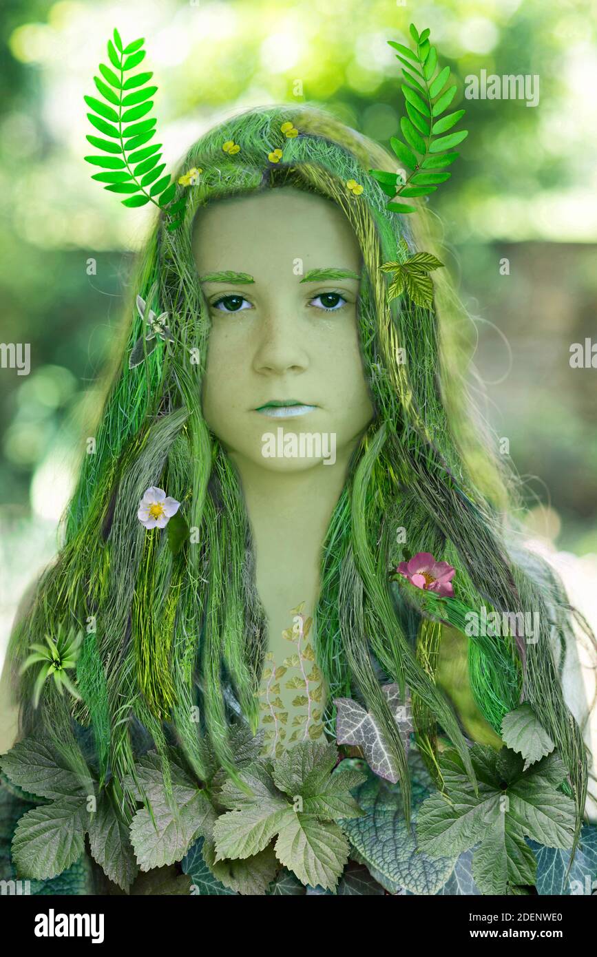 Junge schöne Mädchen mit Haaren aus Gras und Kleid aus Blättern. Ökologie-Konzept. Stockfoto