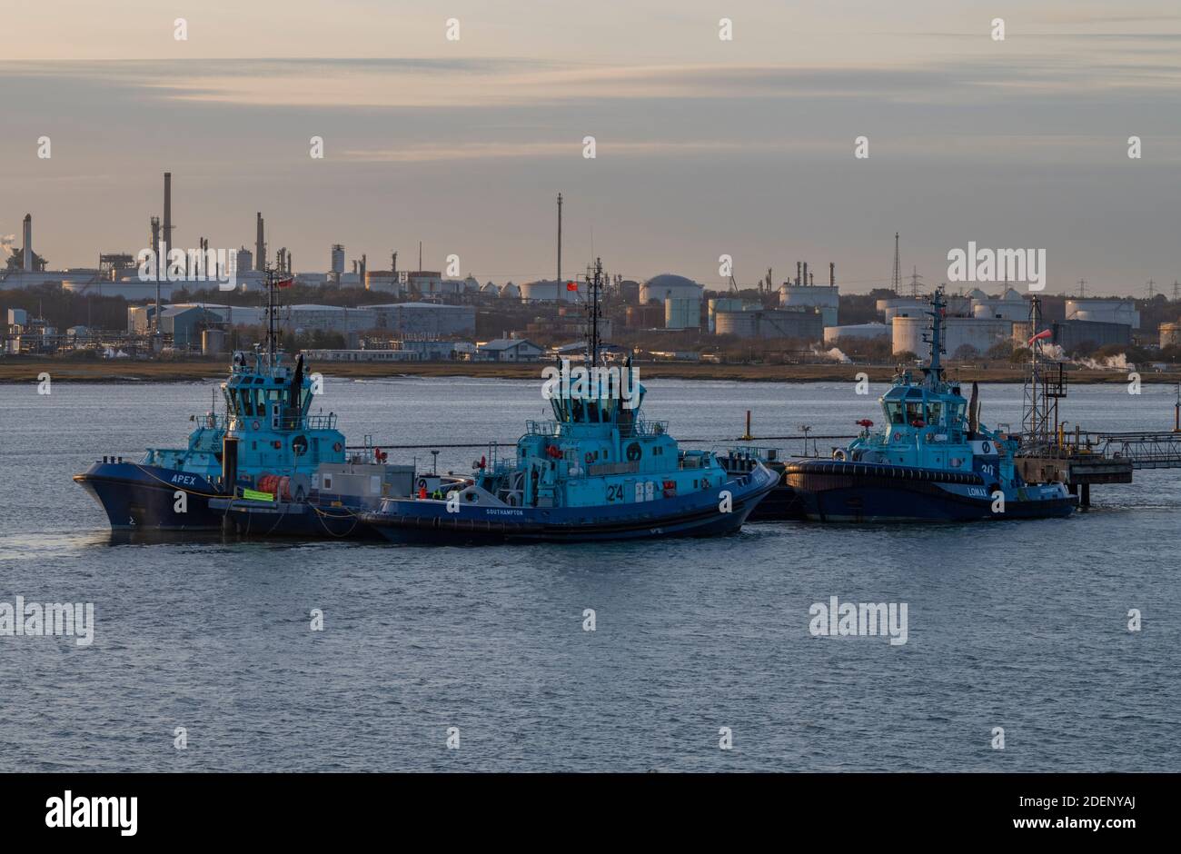 Ostensjo rederi Schleppschlepper, die auf einem Lastkahn oder Ponton am Marinepol der fawley-Ölraffinerie, southampton, hampshire, großbritannien, festgemacht sind Stockfoto