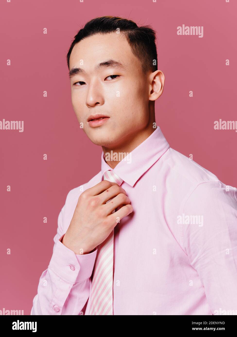 Asian Mann in rosa Hemd gerade seine Krawatte abgeschnitten Ansicht  Attraktiver rosa Hintergrund aussehen Stockfotografie - Alamy