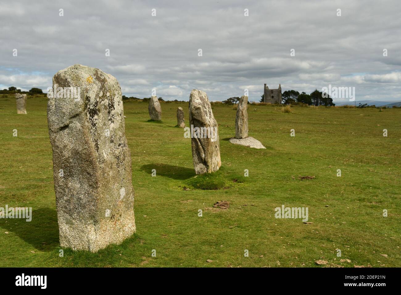 Ein Teil der späten Jungsteinzeit oder frühen Bronzezeit Prähistorische Hurlers Steinkreis auf Bodmin Moor mit den Ruinen Eines Tin Mine Maschinenhauses in der Stockfoto