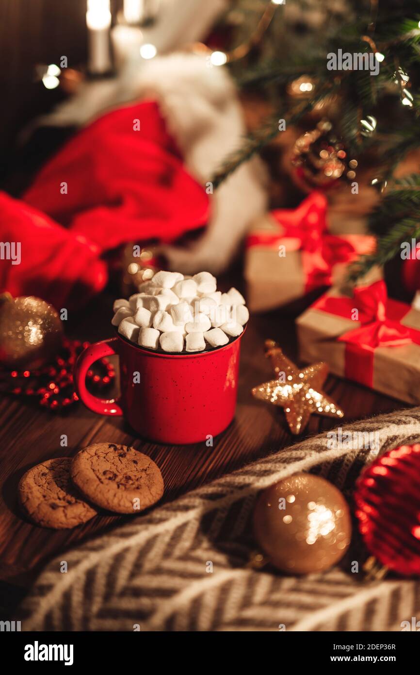 Weihnachtliche rote Tasse mit Kakao und Marshmallows und Keksen auf einem  Holztisch. Neujahr Stillleben mit einem Weihnachtsbaum, einem  Weihnachtsmütze und festlicher Deko Stockfotografie - Alamy