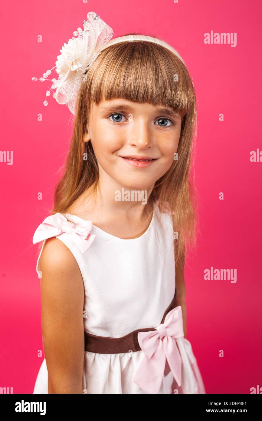 Porträt eines schönen kleinen Mädchens, auf einem rosa Hintergrund im Studio Stockfoto