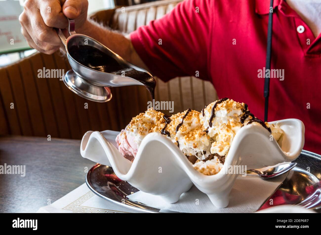 Banane Split mit Mann Gießen heiße Schokolade Sirup auf Stockfoto